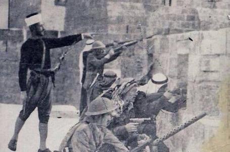 صورة نادرة لإمام المسجد الأقصى يقف على سور القدس فوق باب الخليل ويُعطي التعليمات للثوّار